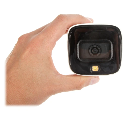 Kamera monitoringu w kształcie kwadratu z czarnym frontem i obiektywem pośrodku, trzymana w dłoni. Poniżej obiektywu znajduje się mała dioda LED.