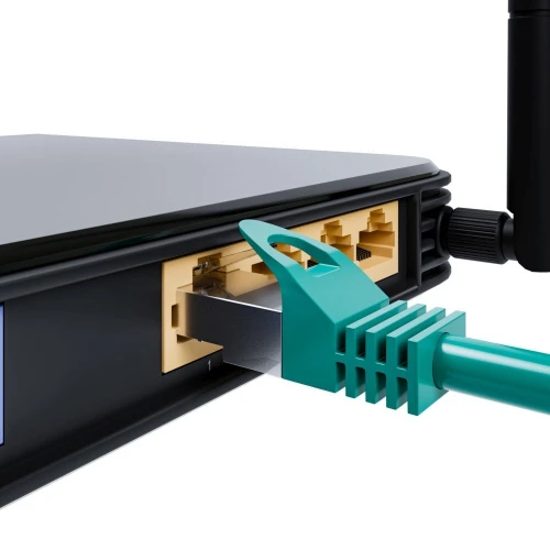 Zbliżenie na tylny panel routera z podłączonym kablem Ethernet do jednego z portów LAN. Kabel ma zielony kolor, a router jest czarny z widoczną anteną po prawej stronie.