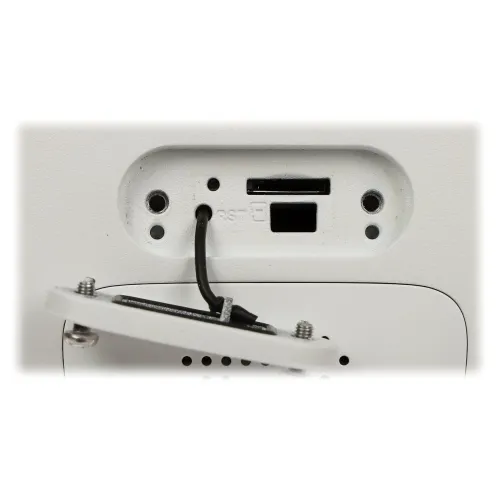 Zdjęcie przedstawia gniazdo na kartę pamięci oraz przycisk reset umieszczone na białej obudowie urządzenia. Widoczna jest również odchylona pokrywa z przewodem.