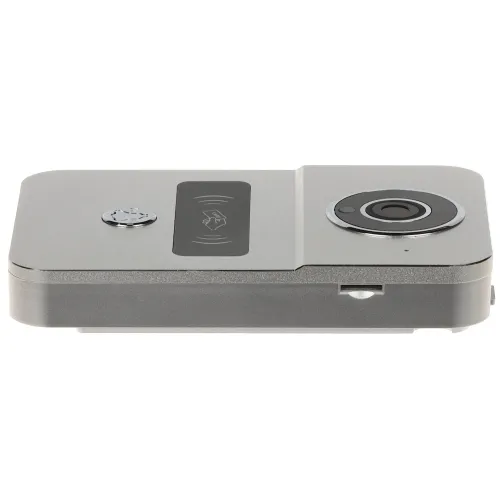 Srebrne urządzenie elektroniczne z okrągłym obiektywem po prawej stronie i przyciskiem po lewej stronie. Na środku znajduje się symbol NFC, a na boku widoczny jest slot na kartę pamięci.