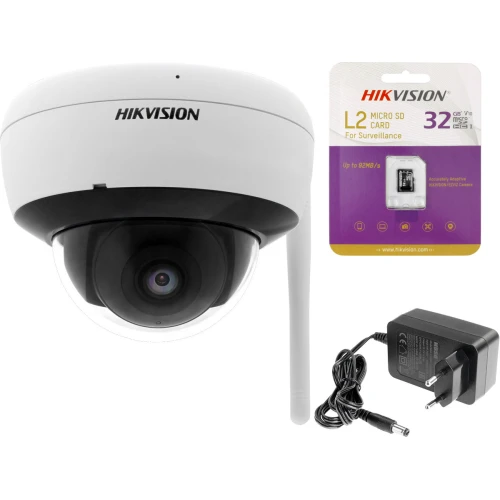 Bezprzewodowa kamera WiFi Hikvision o rozdzielczości 4MP z widoczną anteną, obok której znajduje się karta microSD 32GB oraz zasilacz. Kamera ma kopułkowy kształt i jest przeznaczona do monitoringu.