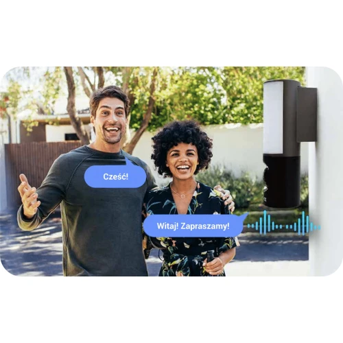 Bezprzewodowa kamera WiFi 4MP zamontowana na zewnętrznej ścianie budynku, obok której stoją dwie uśmiechnięte osoby. Kamera posiada funkcję komunikacji głosowej, co jest zilustrowane dymkami z tekstem.