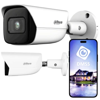 Na zdjęciu znajduje się biała kamera monitoringu marki Dahua zamontowana na ścianie, obok której widoczny jest smartfon z aplikacją DMSS pokazującą obraz z kamery. Kamera ma nowoczesny design z czarnymi akcentami wokół obiektywu.