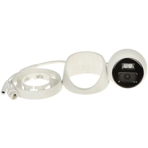 Na zdjęciu znajduje się biała kamera monitoringu z wyjętym pierścieniem zaciskowym, obok której leżą elementy montażowe. Kamera posiada obiektyw oraz dwa widoczne diody LED na czarnym tle.