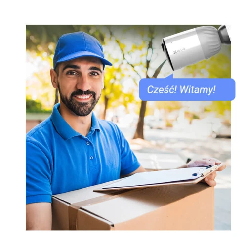 Mężczyzna w niebieskiej czapce i koszulce trzyma paczkę oraz clipboard na tle zieleni. Obok niego widoczna jest kamera z napisem "Cześć! Witamy!".