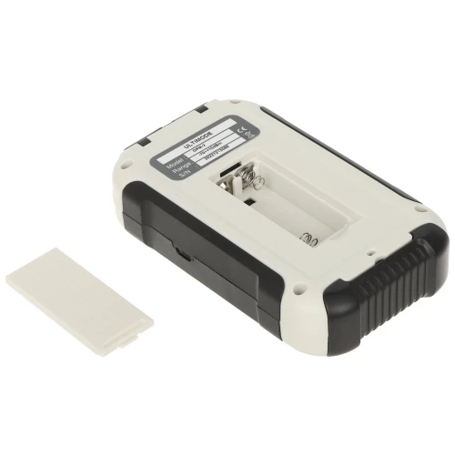 Zdjęcie przedstawia biało-czarną obudowę urządzenia z otwartym miejscem na dwie baterie AAA. Obok leży zdjęta pokrywa komory baterii.