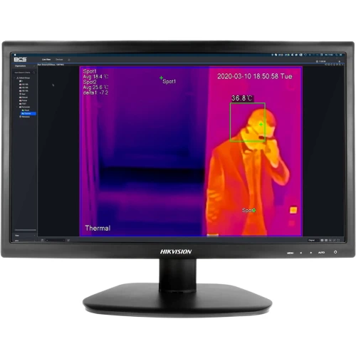 Na zdjęciu znajduje się system pomiaru temperatury ludzkiego ciała z wykorzystaniem kamery termowizyjnej BCS, zamontowany na statywie. W tle widoczny jest ekran monitora wyświetlający obraz termowizyjny.