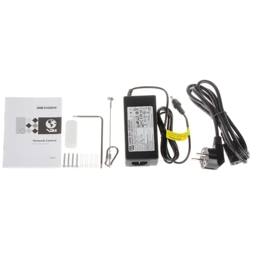 Zestaw zawiera instrukcję obsługi kamery sieciowej, zasilacz, kabel zasilający, klucz imbusowy, kołki montażowe oraz inne akcesoria montażowe. Wszystkie elementy są ułożone na białym tle.