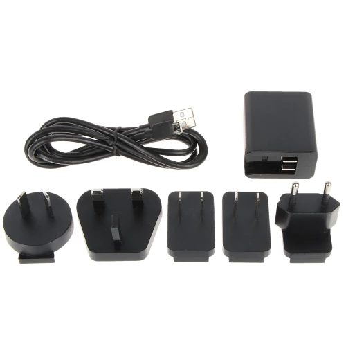 Na zdjęciu znajduje się zestaw ładowarki z różnymi wymiennymi końcówkami do gniazdek elektrycznych oraz kablem USB. Końcówki obejmują standardy wtyczek z różnych regionów, umożliwiając użycie ładowarki na całym świecie.