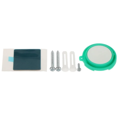 Zestaw montażowy składający się z zielonego uchwytu, dwóch dużych wkrętów, jednego małego wkrętu, dwóch kołków rozporowych oraz samoprzylepnej podkładki. Uchwyt ma okrągły kształt z białym środkiem, a podkładka jest prostokątna z niebieskim paskiem.
