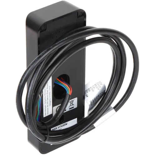 Czarny moduł elektroniczny z widocznymi kolorowymi przewodami i zwojem kabla na wierzchu. Na urządzeniu znajdują się etykiety z informacjami technicznymi.