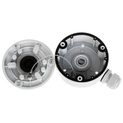 Zdjęcie przedstawia dwie części okrągłej, białej obudowy montażowej z widocznymi elementami mocującymi i otworami na przewody. Wewnątrz obudowy znajduje się metalowy uchwyt z linką zabezpieczającą.