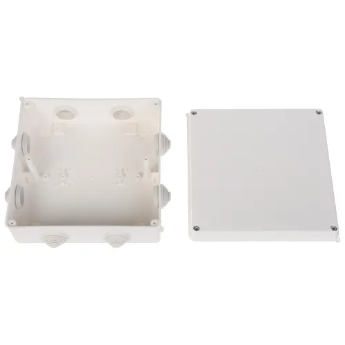 Na zdjęciu znajduje się biała, plastikowa puszka elektryczna z otwartą pokrywą, ukazująca wnętrze z kilkoma otworami na przewody. Obok leży zdejmowana pokrywa z czterema śrubami w rogach.