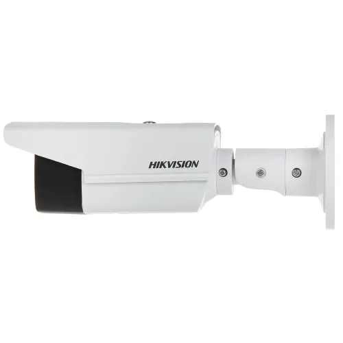 Biała kamera monitoringu marki Hikvision widziana z boku, zamontowana na uchwycie ściennym. Kamera ma cylindryczny kształt z czarnym frontem.