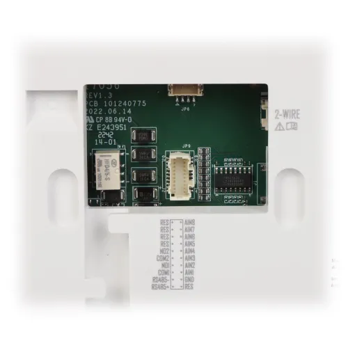 Zdjęcie przedstawia zbliżenie na płytkę drukowaną z różnymi komponentami elektronicznymi, w tym złączami i oznaczeniami technicznymi. W tle widoczne są fragmenty obudowy urządzenia z wycięciami na złącza.