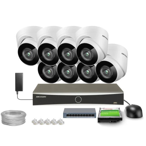 Zestaw do monitoringu składający się z ośmiu kamer, rejestratora, dysku twardego, zasilacza, kabla oraz złączek. Kamery są białe, a rejestrator i inne akcesoria mają ciemne wykończenie.