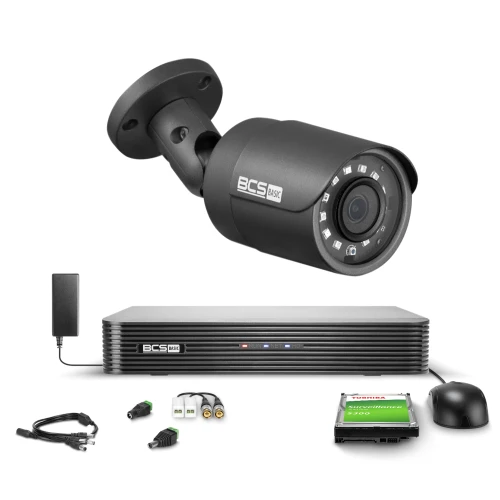 Na zdjęciu znajduje się zestaw do monitoringu, w skład którego wchodzi kamera, rejestrator, dysk twardy, myszka oraz różne kable i złącza. Kamera i rejestrator są oznaczone logo BCS, a dysk twardy ma etykietę Toshiba.