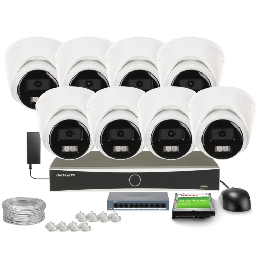 Na zdjęciu znajduje się zestaw do monitoringu, składający się z ośmiu białych kamer kopułkowych, rejestratora, kabla, złączy oraz karty pamięci. Wszystkie elementy są ułożone na białym tle, prezentując kompletny system zabezpieczeń.