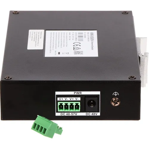 Na zdjęciu znajduje się czarne urządzenie elektroniczne z etykietą na górze, posiadające złącza zasilania oznaczone jako DC 48-57V i DC 48V. Obok urządzenia leży zielony wtyk złącza elektrycznego.