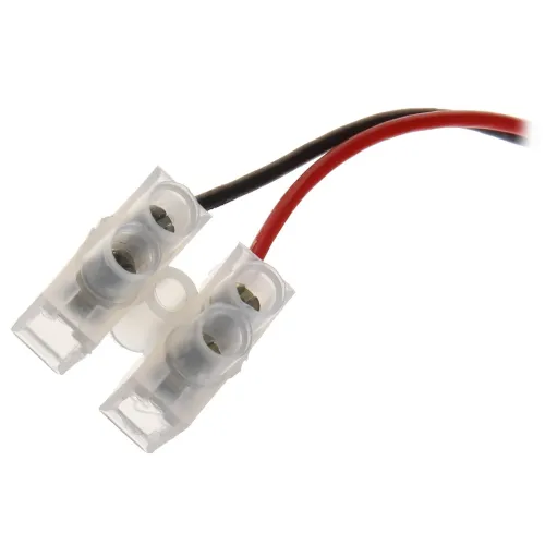 Zdjęcie przedstawia złącze zasilania z dwoma przezroczystymi plastikowymi obudowami, z których wychodzą czerwony i czarny przewód. Złącza mają metalowe elementy wewnętrzne widoczne przez obudowy.